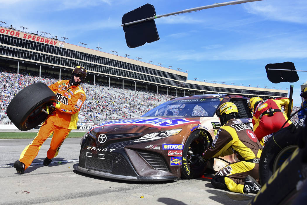 Crew members tend to Kyle Busch's car during a pit stop in a NASCAR Monster Energy NASCAR Cup Series auto race at Atlanta Motor Speedway, Sunday, Feb. 24, 2019, in Hampton, Ga. (AP Photo/Scott Cun ...