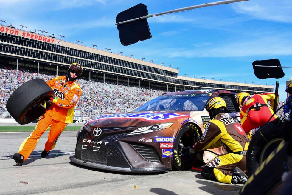 Crew members tend to Kyle Busch's car during a pit stop in a NASCAR Monster Energy NASCAR Cup Series auto race at Atlanta Motor Speedway, Sunday, Feb. 24, 2019, in Hampton, Ga. (AP Photo/Scott Cun ...