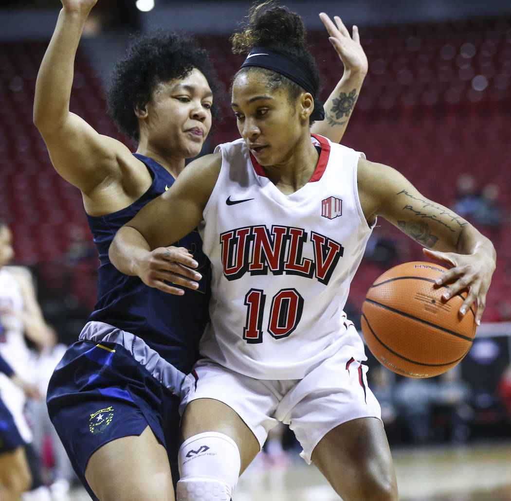UNLV Lady Rebels guard Nikki Wheatley (10) drives as UNR Wolf Pack guard Camariah King (24) defends during the first half of a basketball game in the Mountain West tournament quarterfinals at the ...