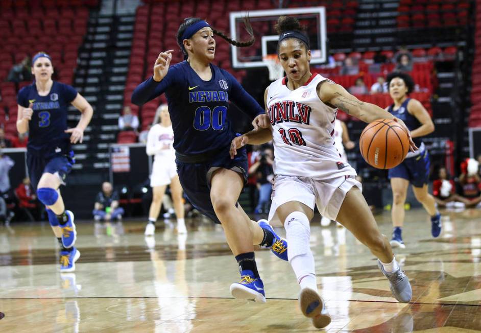 UNLV Lady Rebels guard Nikki Wheatley (10) drives against UNR Wolf Pack guard Janelle Sumilong (00) during the first half of a basketball game in the Mountain West tournament quarterfinals at the ...