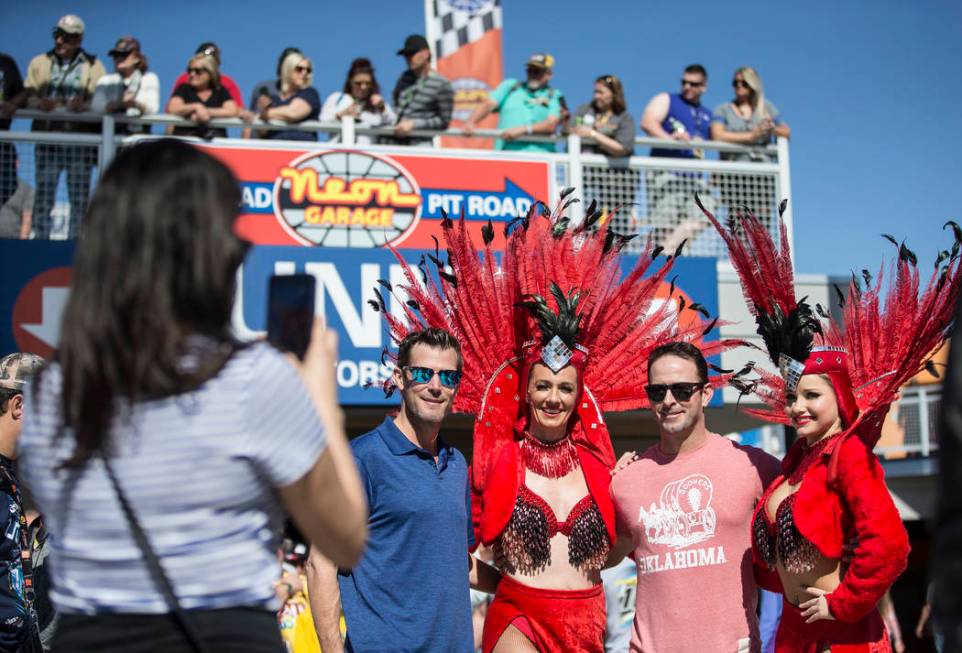 Shane O'Toole, left, and Bryan Baker take a photo with showgirls at the Monster Energy NASCAR Cup Series Pennzoil 400 on Sunday, March 3, 2019, at Las Vegas Motor Speedway, in Las Vegas. (Benjamin ...