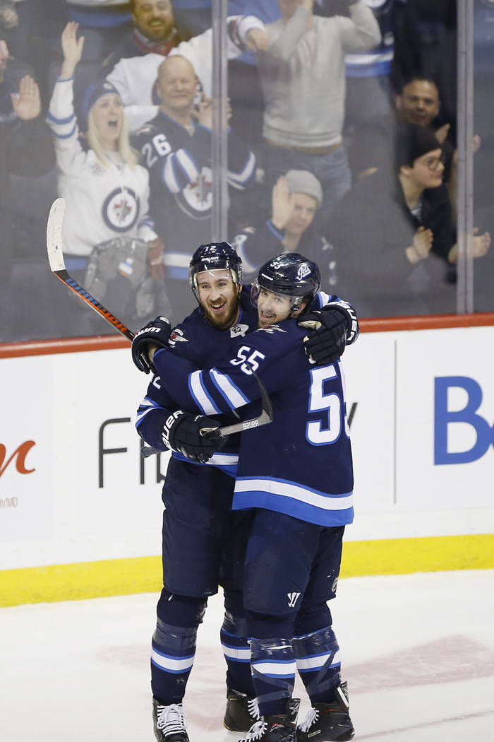 Winnipeg Jets' Kevin Hayes (12) and Mark Scheifele (55) celebrate Hayes' his first goal for the Jets since his recent trade to the team, during the third period of an NHL hockey game against the N ...