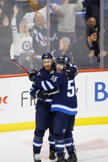 Winnipeg Jets' Kevin Hayes (12) and Mark Scheifele (55) celebrate Hayes' his first goal for the Jets since his recent trade to the team, during the third period of an NHL hockey game against the N ...