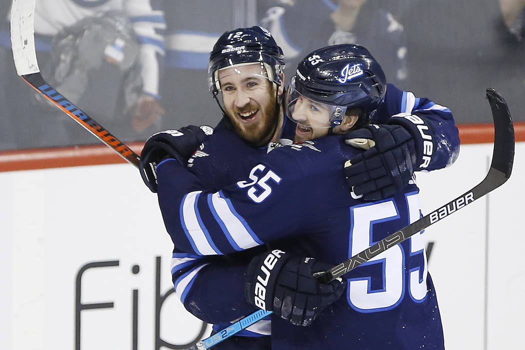 Winnipeg Jets' Kevin Hayes (12) and Mark Scheifele (55) celebrate Hayes' his first goal for the Jets since his recent trade to the team, against the Nashville Predators during the third period of ...