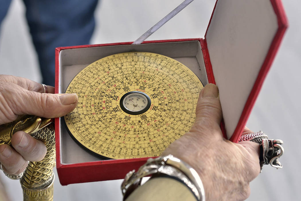 Doc Phineas Kastle demonstrates the use of the feng shui Luo Pan compass, a device to measure the energy or as Chinese refer to as chi or qi. (Bill Hughes/Real Estate Millions)