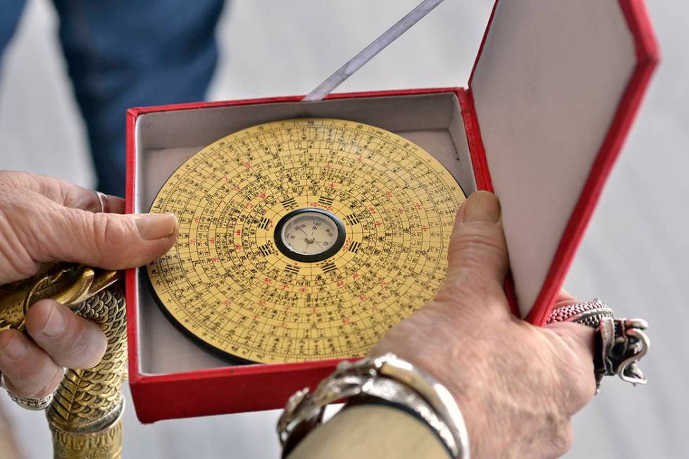 Doc Phineas Kastle demonstrates the use of the feng shui Luo Pan compass, a device to measure the energy or as Chinese refer to as chi or qi. (Bill Hughes/Real Estate Millions)