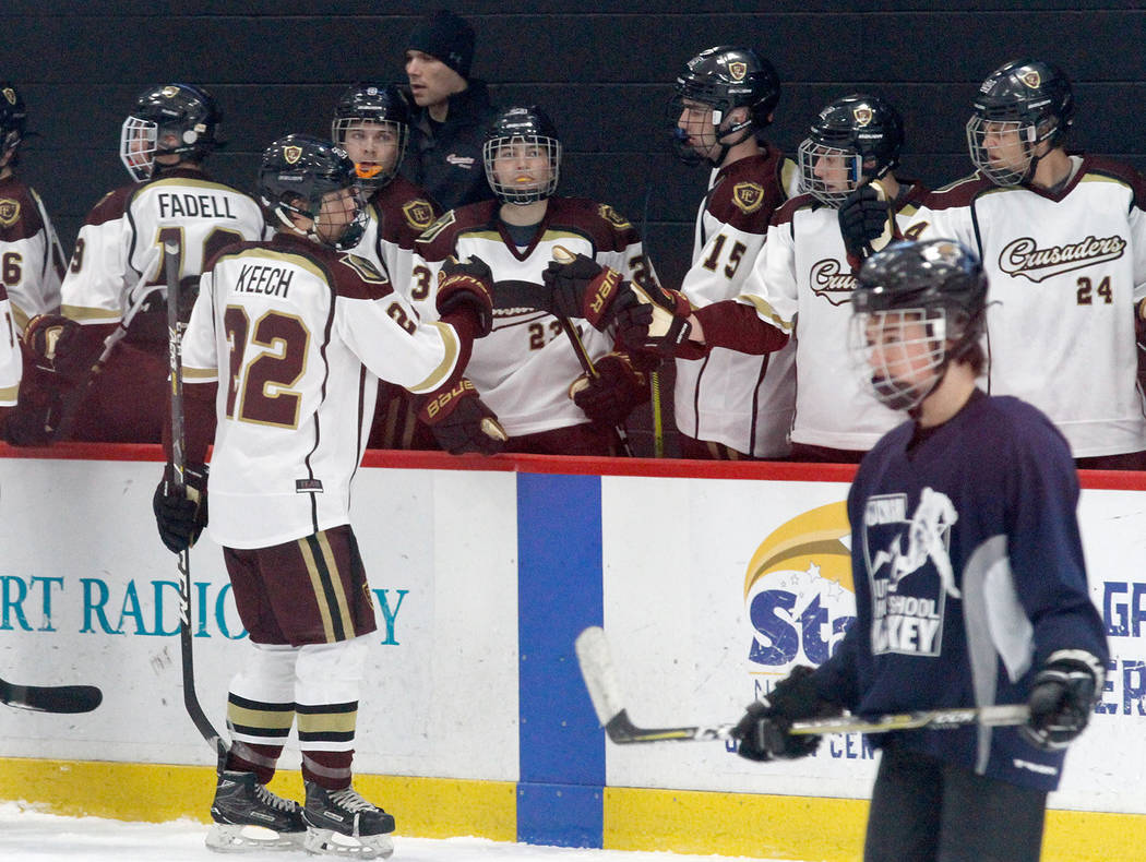 Faith Lutheran's Hunter Keech (22) celebrates with his teammates after he scored a goal against Utah's goaltender during the first period of a hockey game at the City National Arena in Las Vegas, ...