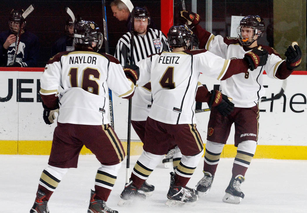 Faith Lutheran's Matty Johnson, right, celebrates with his teammates Colton Fleitz (4) and Joseph Naylor (16) after Johnson scored a goal against Utah's goaltender during the first period of a hoc ...