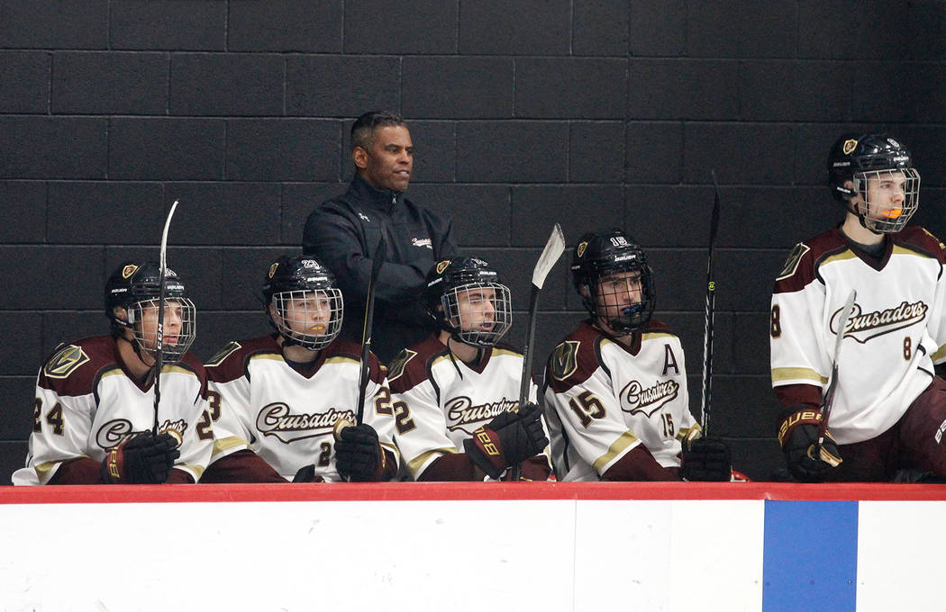 Faith Lutheran's head coach Pokey Roddick, center, watches the hockey game with his players against Utah during the second period at the City National Arena in Las Vegas, Saturday, Dec. 15, 2018. ...