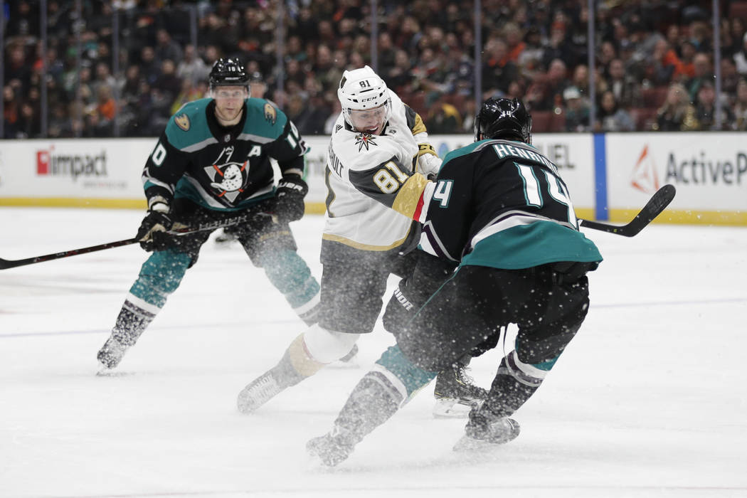 Vegas Golden Knights' Jonathan Marchessault, center, shoots as Anaheim Ducks' Adam Henrique defends during the first period of an NHL hockey game Friday, March 1, 2019, in Anaheim, Calif. (AP Phot ...