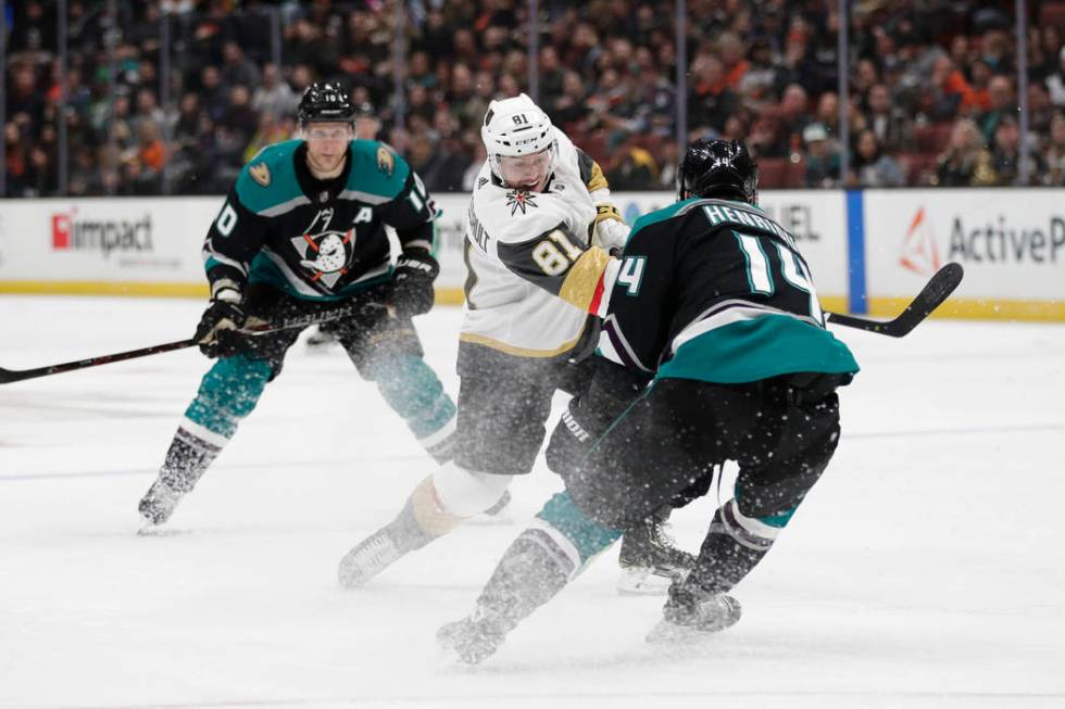 Vegas Golden Knights' Jonathan Marchessault, center, shoots as Anaheim Ducks' Adam Henrique defends during the first period of an NHL hockey game Friday, March 1, 2019, in Anaheim, Calif. (AP Phot ...