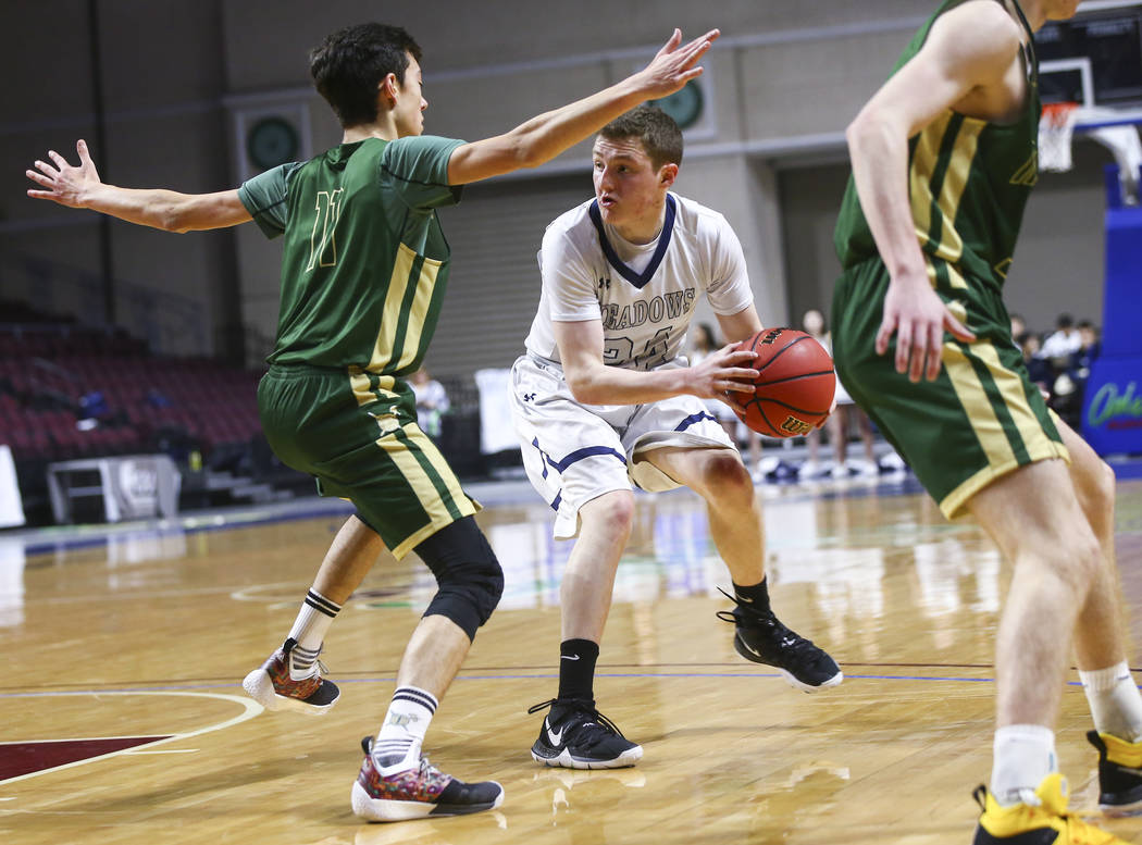 The Meadows guard Allen Fridman (24) moves the ball around Incline guard Johnny Redfern (11) during the first half of the Class 2A boys basketball state championship game at the Orleans Arena in L ...