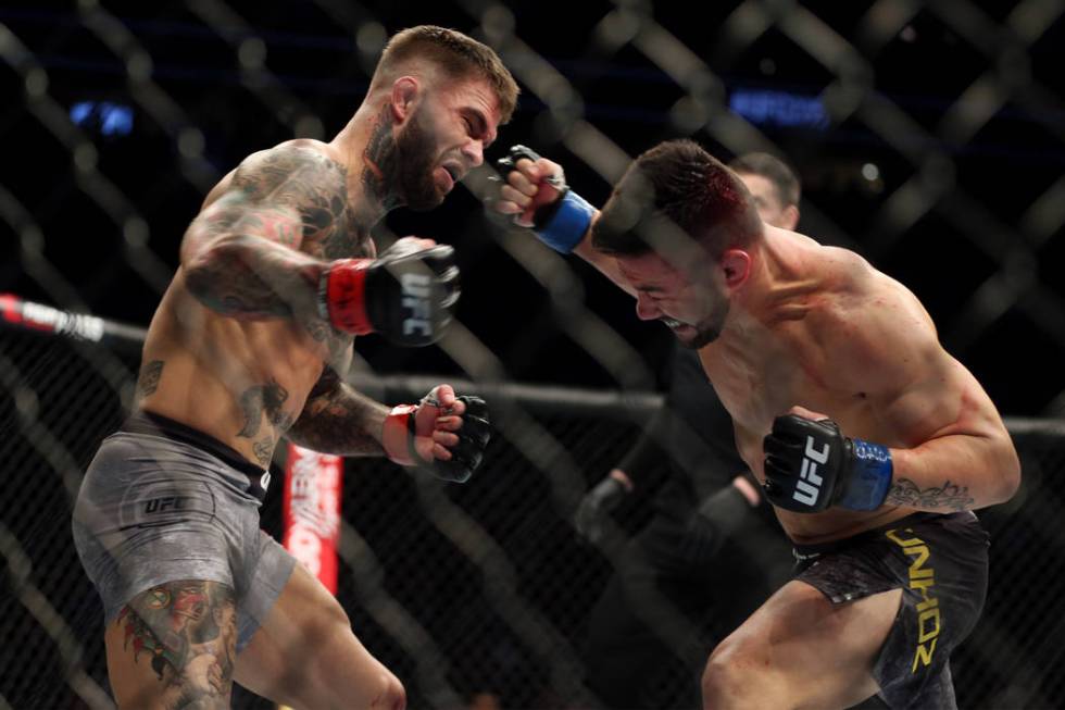 Pedro Munhoz, right, connects a punch to knockout Cody Garbrandt in the first round of the bantamweight bout during UFC 235 at T-Mobile Arena in Las Vegas, Saturday, March 2, 2019. (Erik Verduzco/ ...