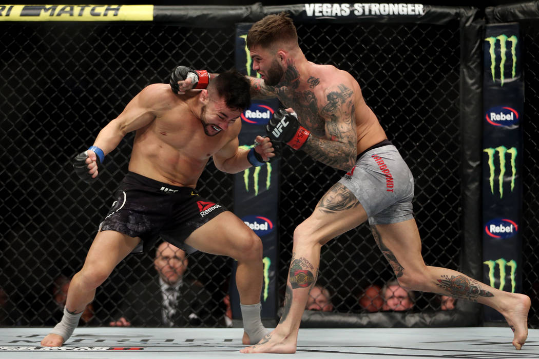 Pedro Munhoz, left, battles Cody Garbrandt in the first round of the bantamweight bout during UFC 235 at T-Mobile Arena in Las Vegas, Saturday, March 2, 2019. Munhoz won by way of knockout in the ...