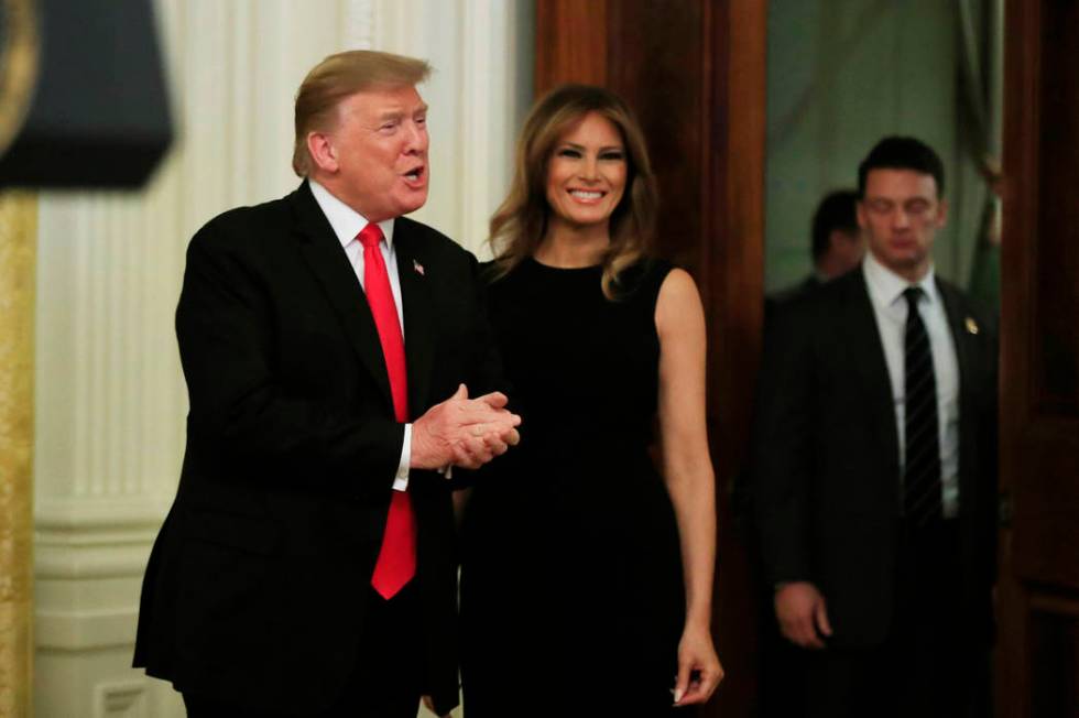 President Donald Trump with first lady Melania Trump, greets invited guests during a National African American History Month reception in the East Room of the White House in Washington, Thursday, ...