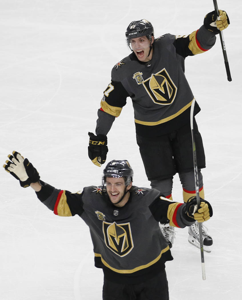Vegas Golden Knights left wing David Perron, top, and defenseman Colin Miller celebrate after defenseman Jon Merrill scored against the Pittsburgh Penguins during the third period of an NHL hockey ...