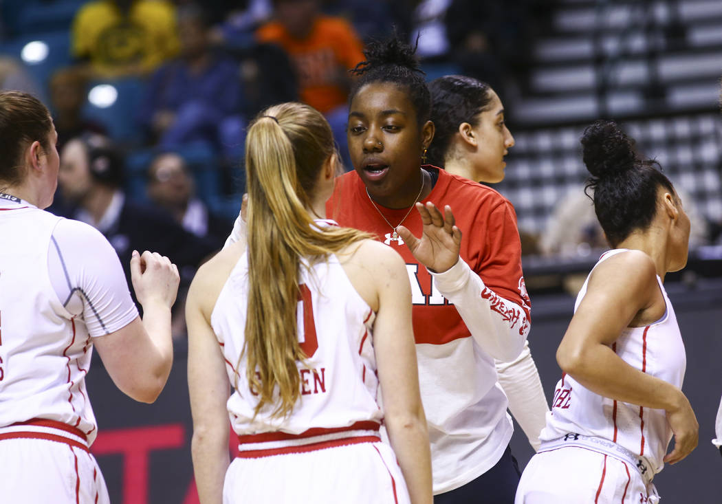 Former Liberty basketball player Dre'Una Edwards, who now plays for Utah, right, talks with teammate Dru Gylten before the start of a game against Washington during the Pac-12 women's basketball t ...