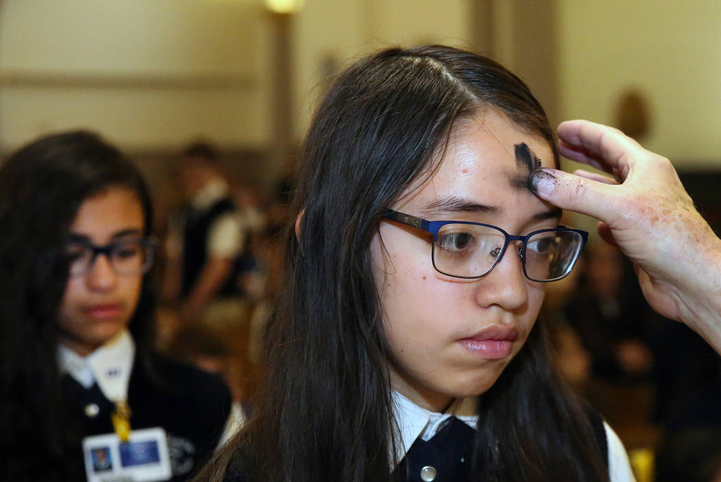 Rev. Larry Lentz applies ashes on St. Viator Parish School student, Jasmine Cortez, forehead at St. Viator Catholic Church during Ash Wednesday on Wednesday, March. 6, 2019, in Las Vegas. Bizuayeh ...