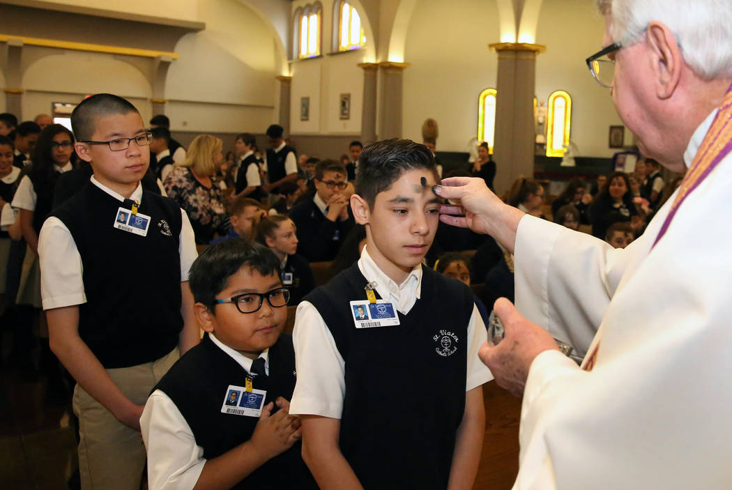 Rev. Larry Lentz applies ashes on St. Viator Parish School student Adrian Galvez forehead at St. Viator Catholic Church during Ash Wednesday on Wednesday, March. 6, 2019, in Las Vegas. Bizuayehu T ...