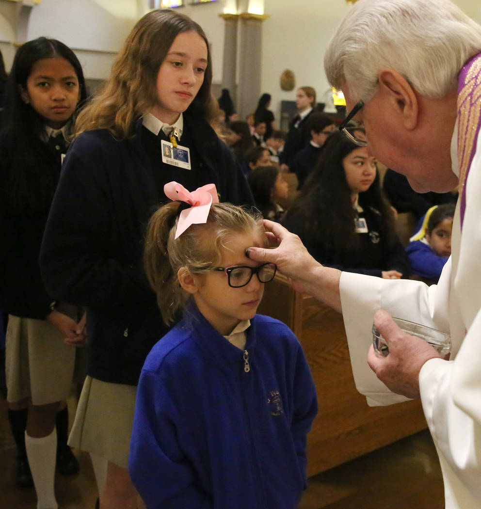 Rev. Larry Lentz applies ashes on a St. Viator Parish School student's forehead at St. Viator Catholic Church during Ash Wednesday on Wednesday, March. 6, 2019, in Las Vegas. Bizuayehu Tesfaye Las ...