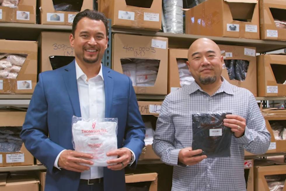 Thompson Tee co-founders Billy Thompson, left, and Randy Choi, right, hold up T-shirts inside a warehouse. (Courtesy)