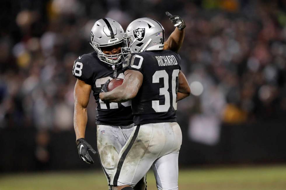 Oakland Raiders running back Jalen Richard (30) celebrates with running back Doug Martin (28) during the second half of an NFL football game against the Denver Broncos in Oakland, Calif., Monday, ...