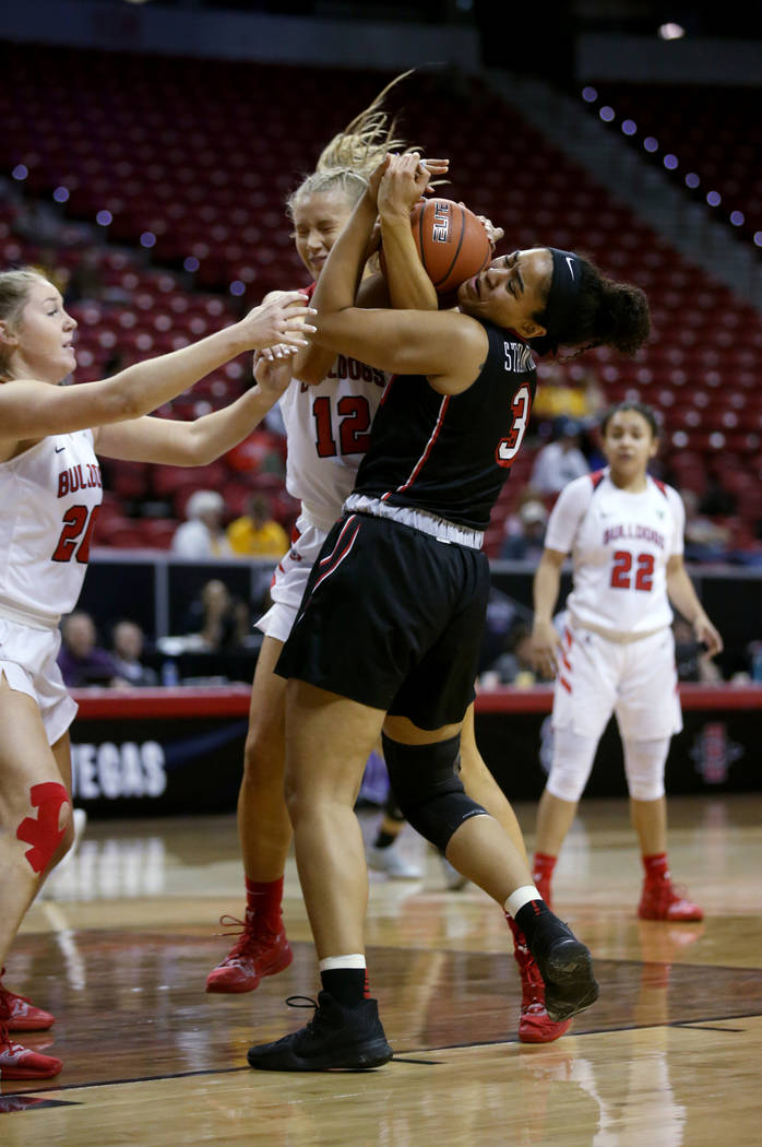 UNLV Lady Rebels forward Paris Strawther (3) battles for the ball with Fresno State Bulldogs forward Genna Ogier (12) in the first period of their quarterfinal game of the Mountain West women's ba ...