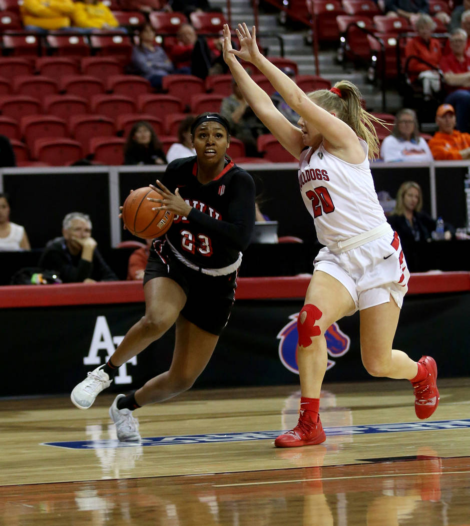 UNLV Lady Rebels forward Jordyn Bell (23) drives past Fresno State Bulldogs guard Bree Delaney (20) in the first quarter of their quarterfinal game of the Mountain West women's basketball tourname ...