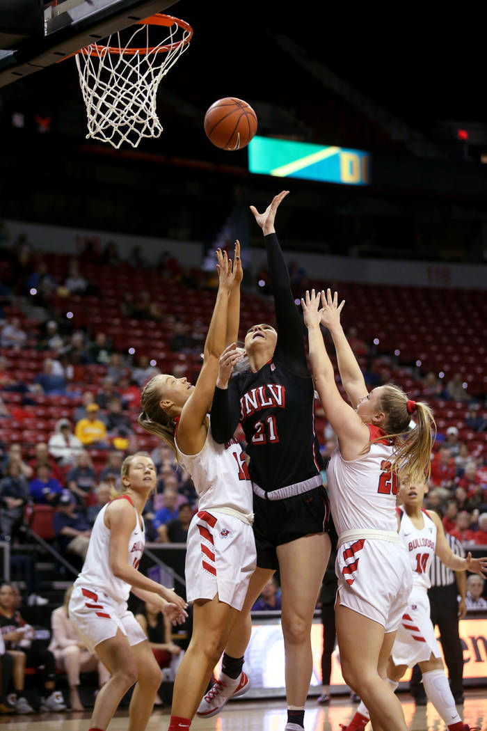 UNLV Lady Rebels forward Katie Powell (21) shoots between Fresno State Bulldogs forward Lydia Friberg (21) and guard Bree Delaney (20) in the third quarter of their quarterfinal game in the Mounta ...