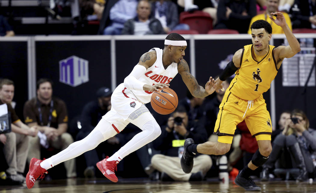 New Mexico's Keith McGee drives while defended by Wyoming's Justin James during the first half of an NCAA college basketball game in the Mountain West Conference tournament, Wednesday, March 13, 2 ...