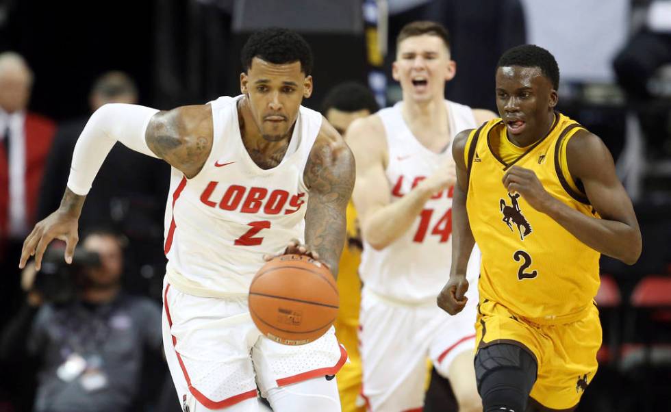 Wyoming's AJ Banks, right, defends as New Mexico's Corey Henson brings the ball up during the second half of an NCAA college basketball game in the Mountain West Conference men's tournament Wednes ...