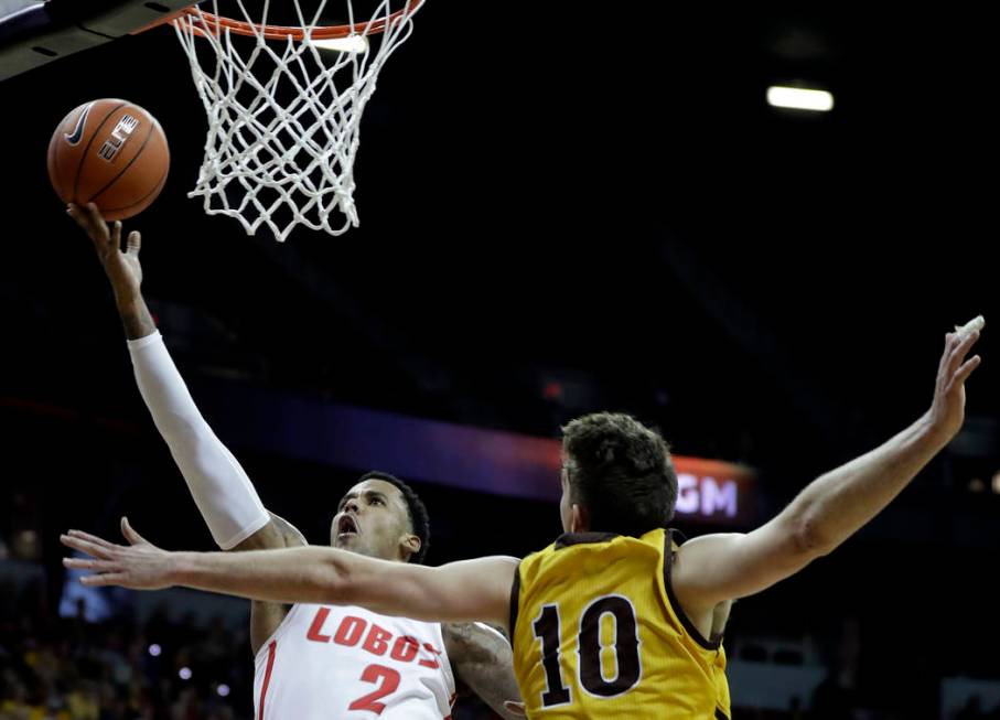 New Mexico's Corey Henson (2) shoots while Wyoming's Hunter Thompson (10) defends during the second half of an NCAA college basketball game in the Mountain West Conference tournament, Wednesday, M ...