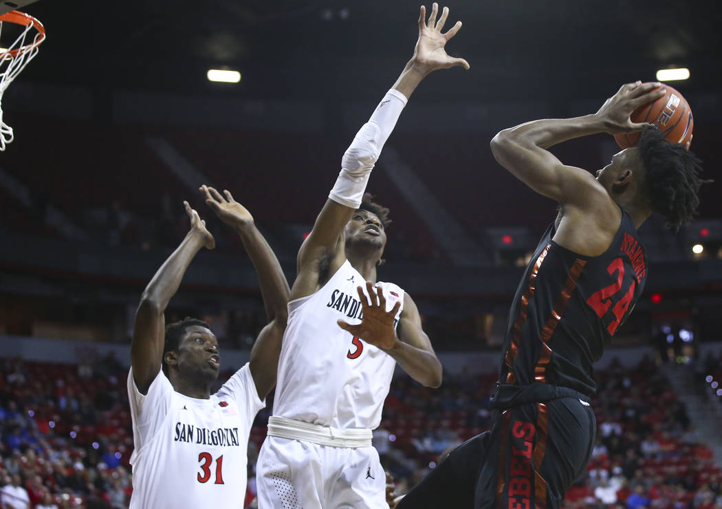 UNLV Rebels forward Joel Ntambwe (24) shoots against San Diego State Aztecs forwards Jalen McDaniels (5) and Nathan Mensah (31) during the first half of a quarterfinal game in the Mountain West me ...