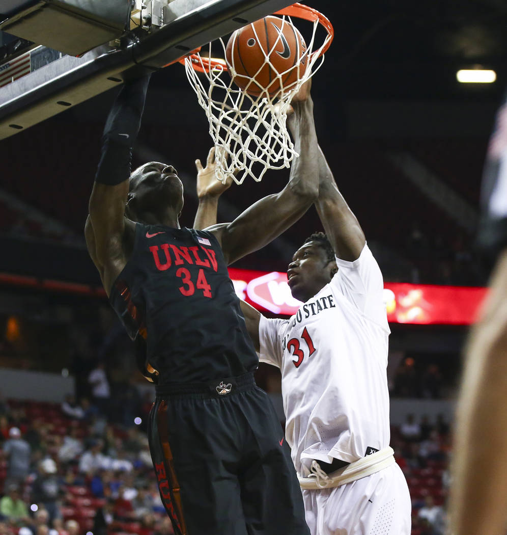 UNLV Rebels forward Cheikh Mbacke Diong (34) dunks against San Diego State Aztecs forward Nathan Mensah (31) during the first half of a quarterfinal game in the Mountain West men's basketball tour ...