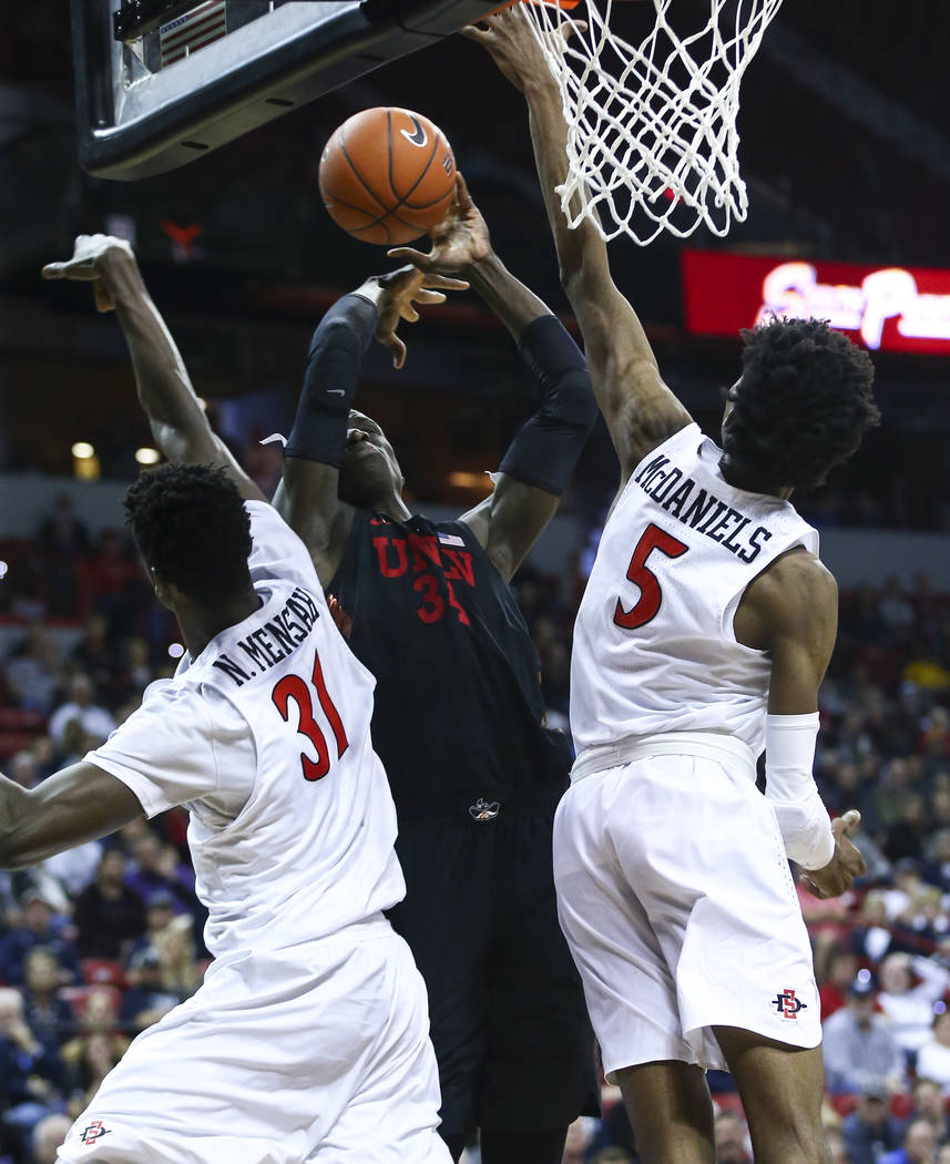UNLV Rebels forward Cheikh Mbacke Diong (34) is fouled by San Diego State Aztecs forward Nathan Mensah (31) while going to the basket under pressure from San Diego State Aztecs forward Jalen McDan ...