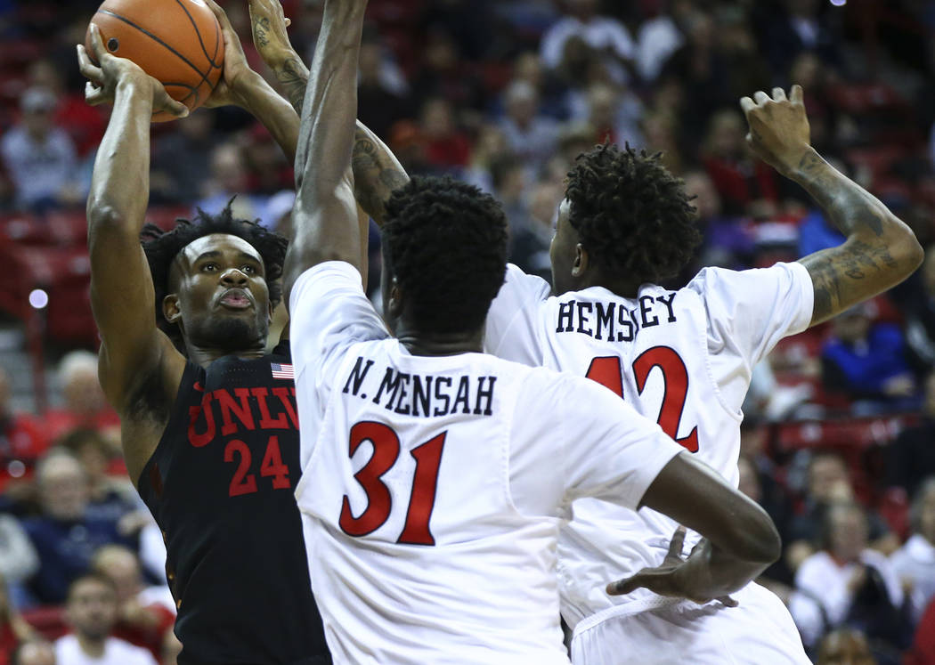 UNLV Rebels forward Joel Ntambwe (24) shoots under pressure from San Diego State Aztecs forward Nathan Mensah (31) and guard Jeremy Hemsley during the second half of a quarterfinal game in the Mou ...