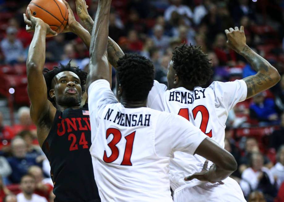 UNLV Rebels forward Joel Ntambwe (24) shoots under pressure from San Diego State Aztecs forward Nathan Mensah (31) and guard Jeremy Hemsley during the second half of a quarterfinal game in the Mou ...