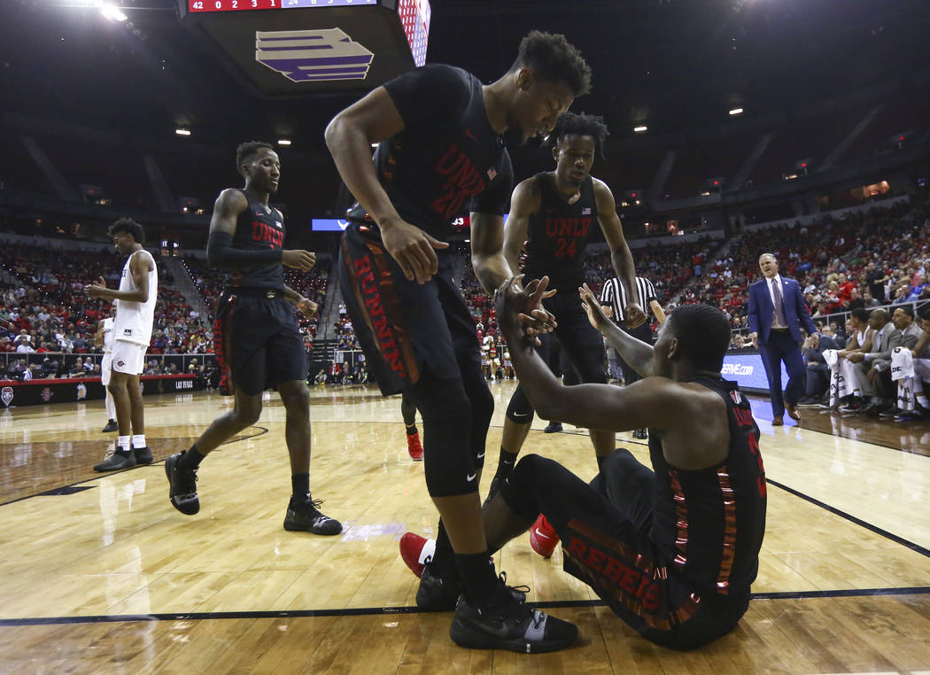 UNLV Rebels forwards Nick Blair (20) and Joel Ntambwe (24) help up guard Amauri Hardy (3) during the first half of a quarterfinal game against San Diego State in the Mountain West men's basketball ...