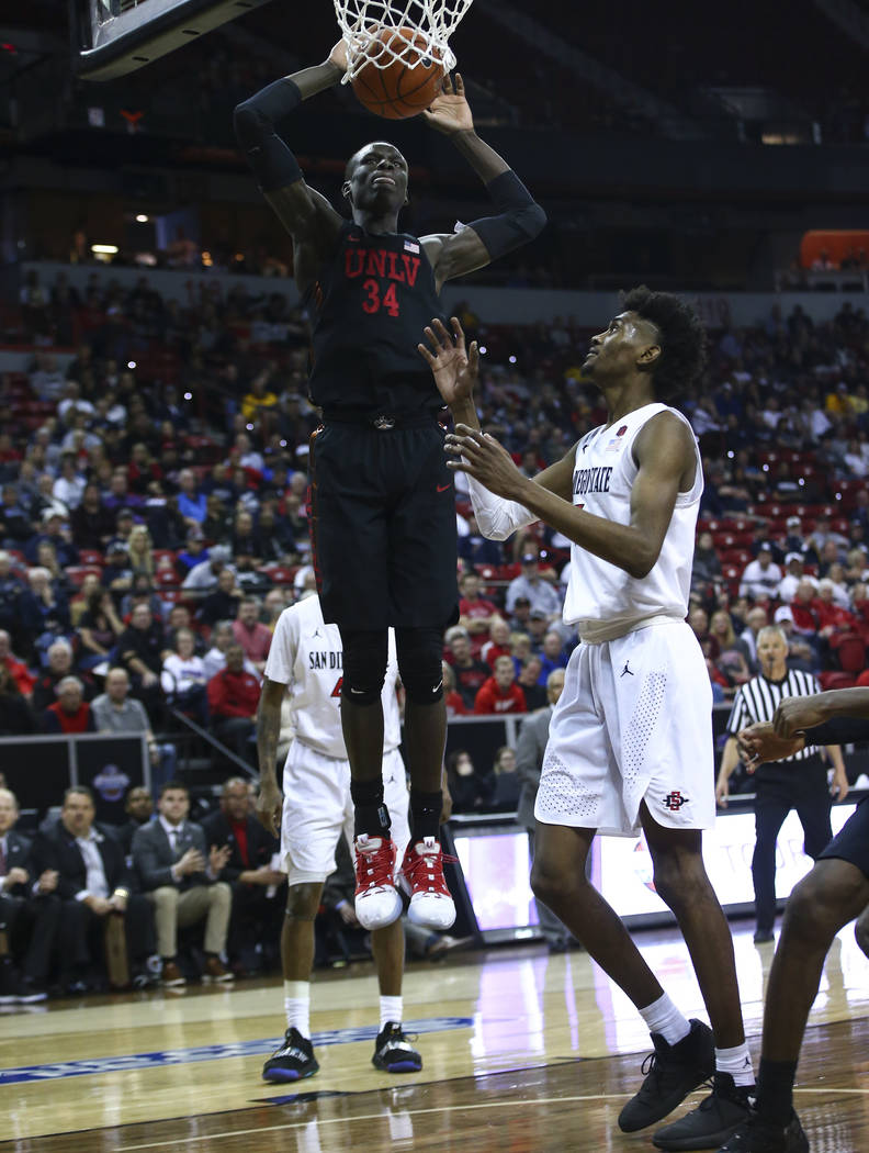 UNLV Rebels forward Cheikh Mbacke Diong (34) dunks over San Diego State Aztecs forward Jalen McDaniels during the second half of a quarterfinal game in the Mountain West men's basketball tournamen ...