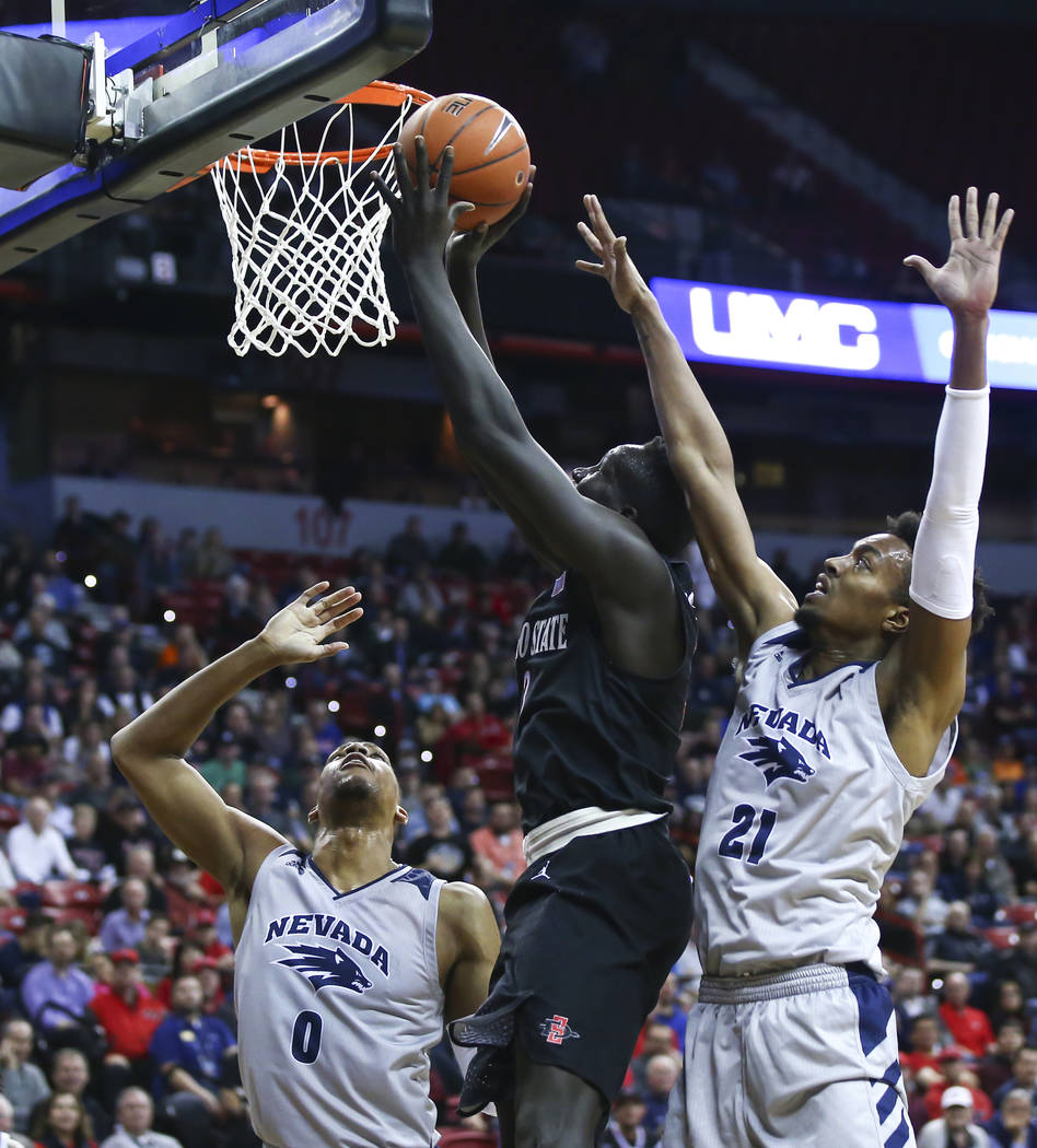 San Diego State Aztecs forward Aguek Arop (3) goes to the basket between UNR Wolf Pack forwards Tre'Shawn Thurman (0) and Jordan Brown (21) during the first half of a semifinal basketball game in ...