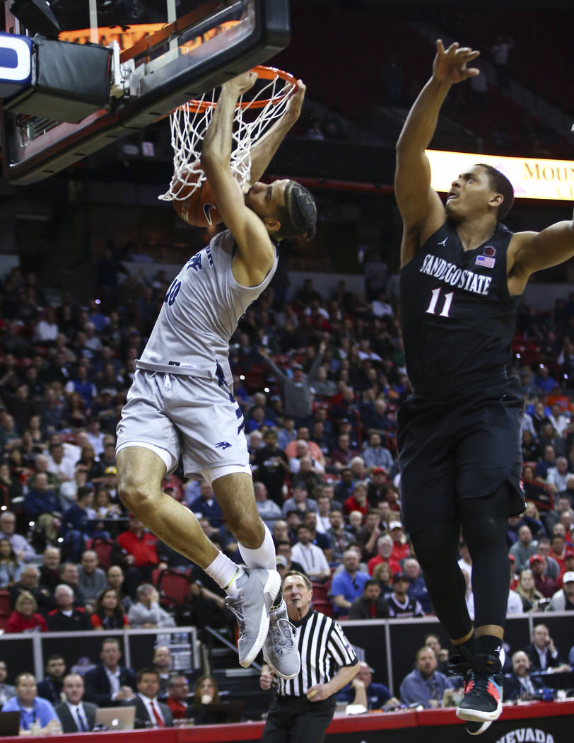 UNR Wolf Pack forward Caleb Martin (10) dunks in front of San Diego State Aztecs forward Matt Mitchell (11) during the second half of a semifinal basketball game in the Mountain West men's basketb ...