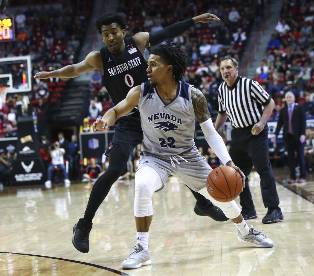 UNR Wolf Pack guard Jazz Johnson (22) moves the ball around under pressure from San Diego State Aztecs guard Devin Watson (0) during the second half of a semifinal basketball game in the Mountain ...