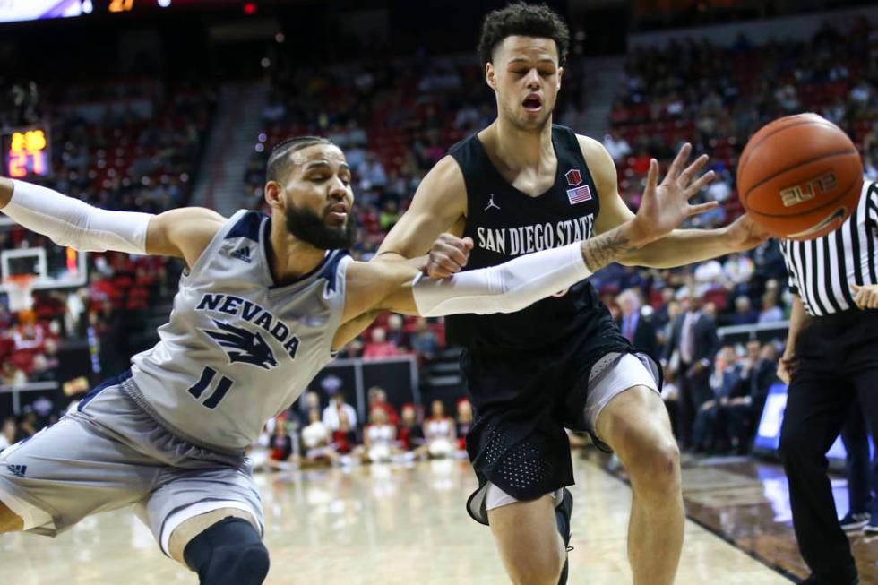 UNR Wolf Pack forward Cody Martin (11) and San Diego State Aztecs guard Jordan Schakel (20) battle for a loose ball during the first half of a semifinal basketball game in the Mountain West men's ...