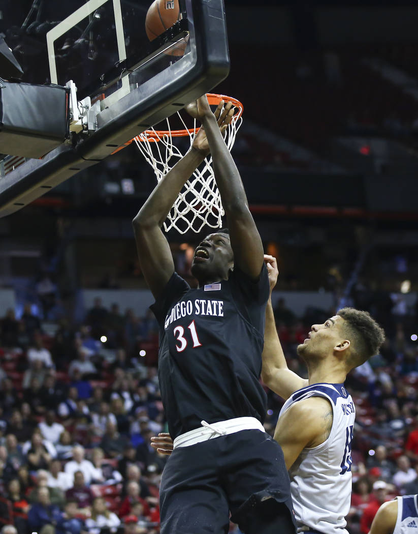 San Diego State Aztecs forward Nathan Mensah (31) goes to the basket against UNR Wolf Pack forward Trey Porter (15) during the first half of a semifinal basketball game in the Mountain West men's ...