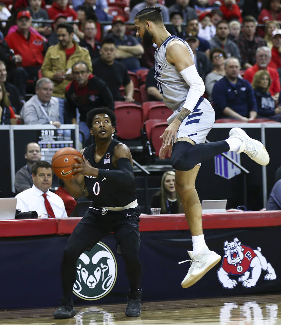 San Diego State Aztecs guard Devin Watson (0) waits to take a shot under pressure from UNR Wolf Pack forward Cody Martin (11) during the first half of a semifinal basketball game in the Mountain W ...