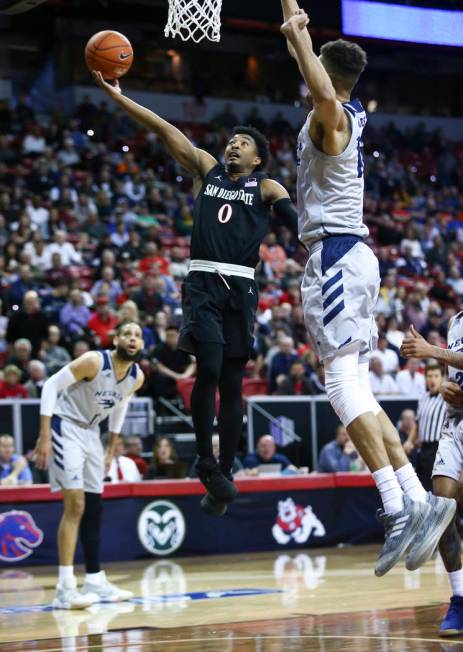 San Diego State Aztecs guard Devin Watson (0) goes to the basket against UNR Wolf Pack forward Trey Porter (15) during the first half of a semifinal basketball game in the Mountain West men's bask ...