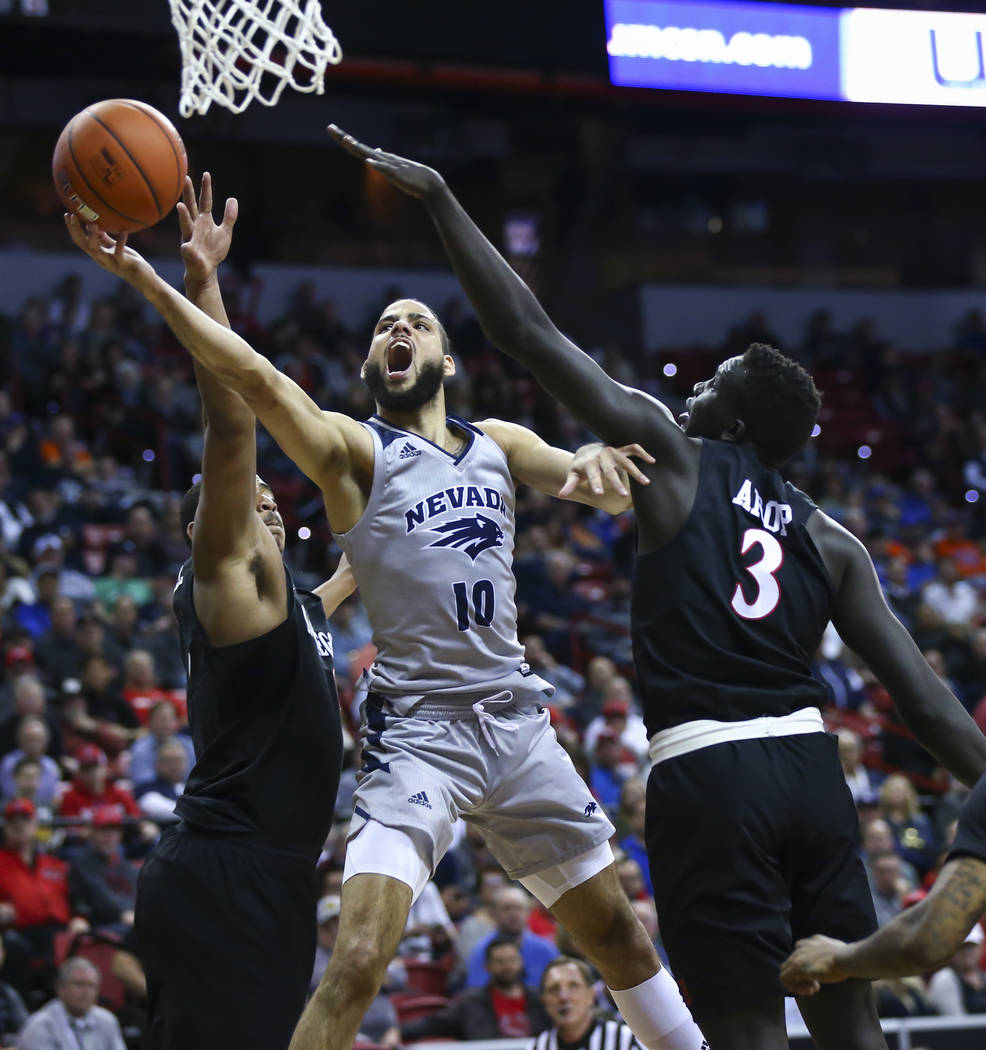 UNR Wolf Pack forward Caleb Martin (10) goes to the basket between San Diego State Aztecs forwards Matt Mitchell, left, and Aguek Arop (3) during the second half of a semifinal basketball game in ...