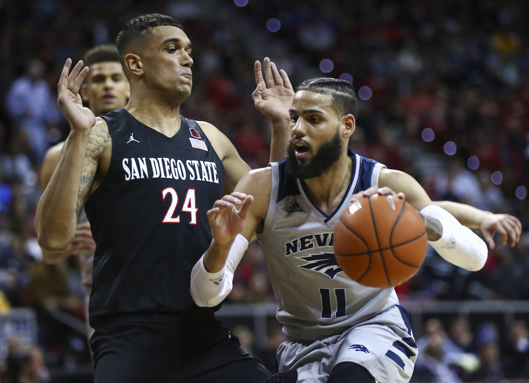 UNR Wolf Pack forward Cody Martin (11) drives against San Diego State Aztecs forward Nolan Narain (24) during the second half of a semifinal basketball game in the Mountain West men's basketball t ...
