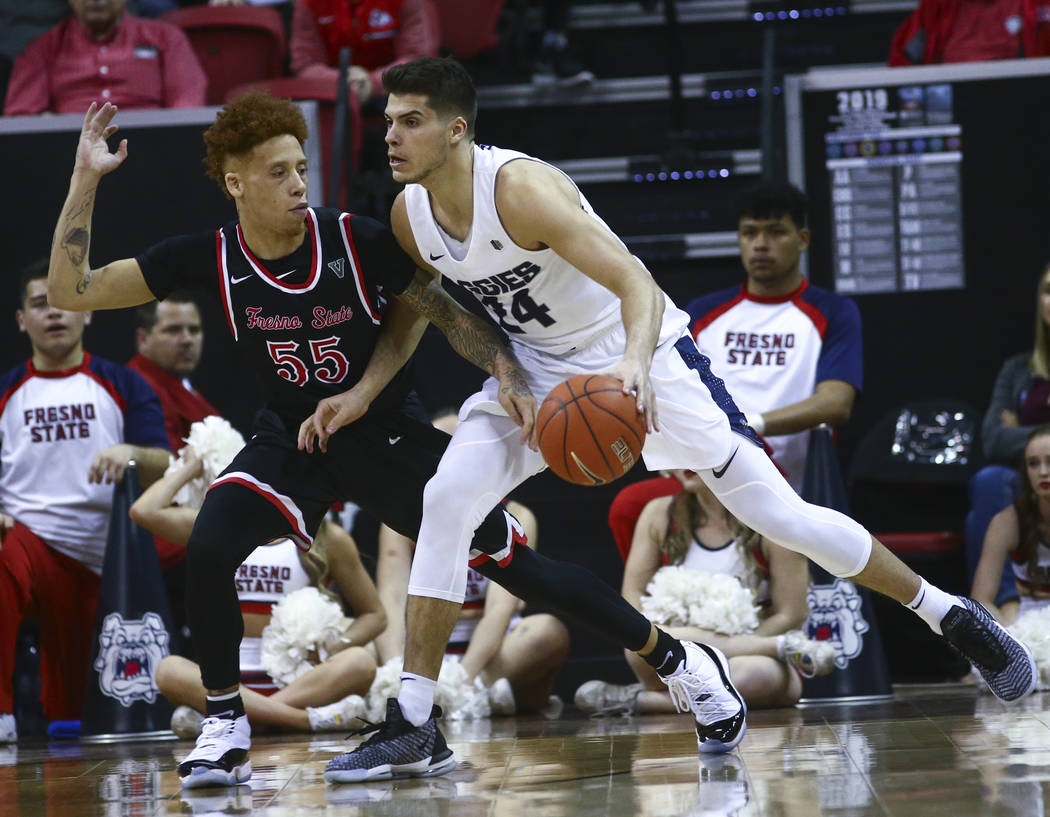 Utah State Aggies guard Diogo Brito (24) moves the ball around Fresno State Bulldogs guard Noah Blackwell (55) during the first half of a semifinal basketball game in the Mountain West men's baske ...