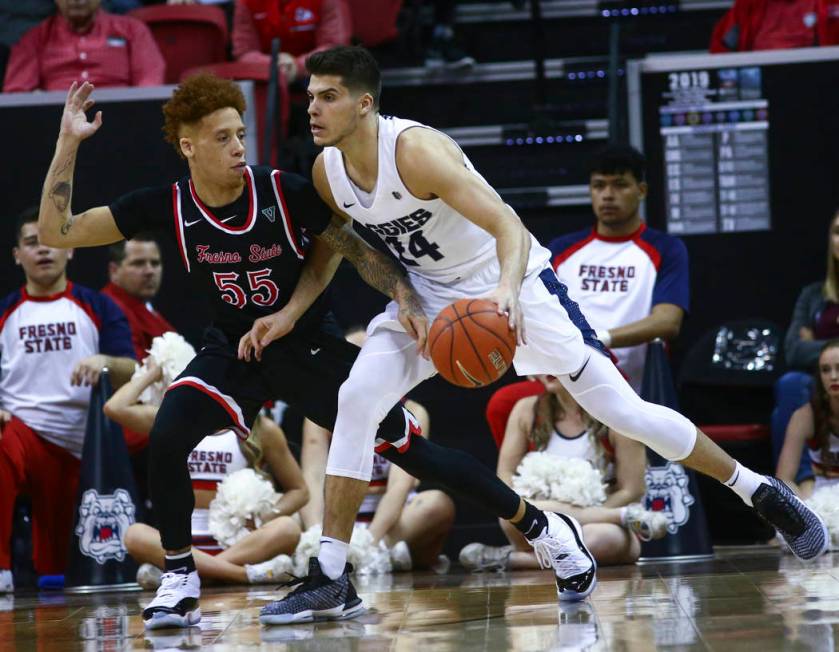 Utah State Aggies guard Diogo Brito (24) moves the ball around Fresno State Bulldogs guard Noah Blackwell (55) during the first half of a semifinal basketball game in the Mountain West men's baske ...